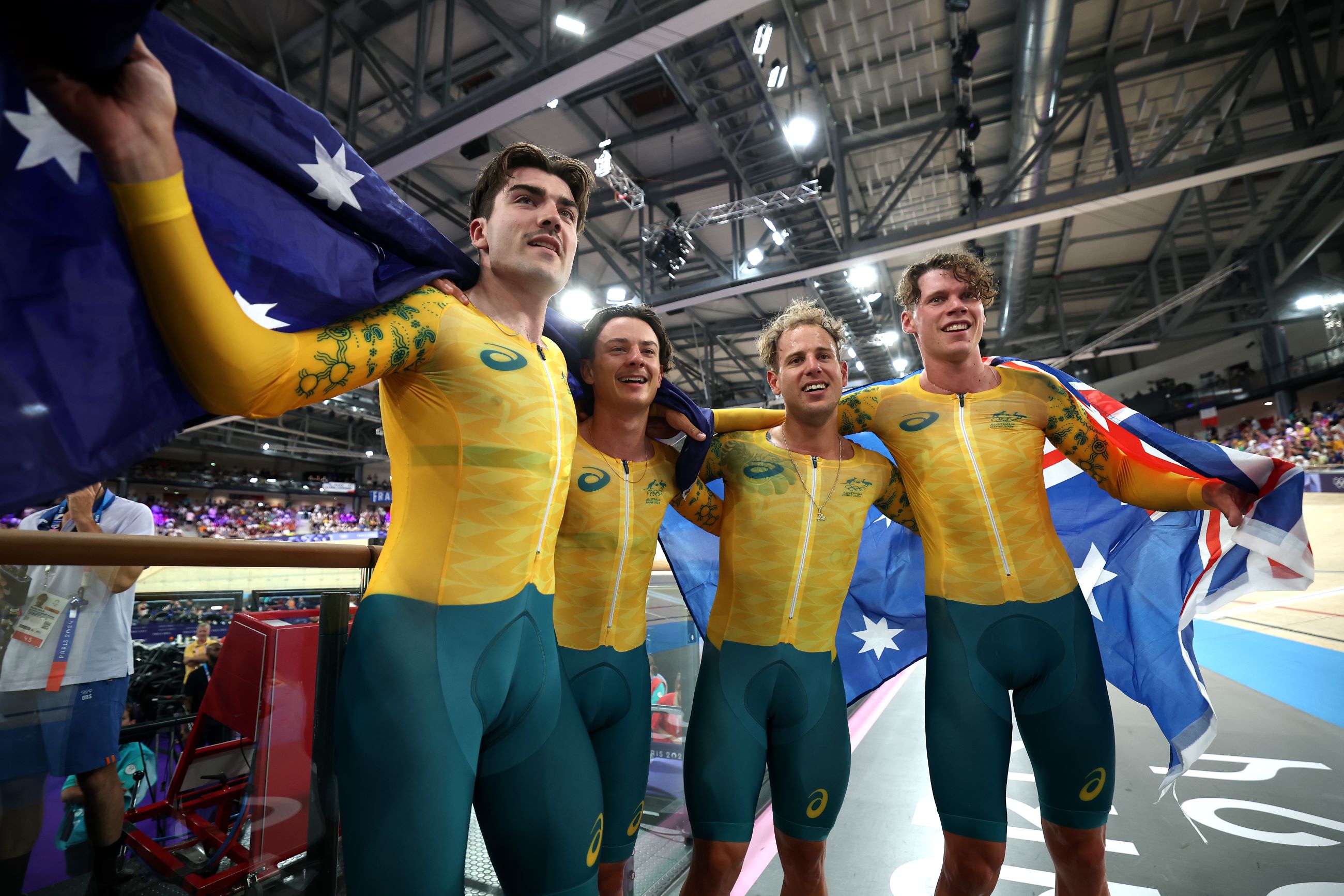 Conor Leahy, Oliver Bleddyn, Sam Welsford and Kelland O'Brien celebrate with the Australian flag immediately after winning the team pursuit gold medal final at the Paris 2024 Olympic Games